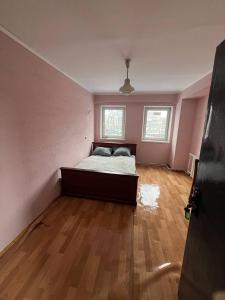 a bedroom with a bed in a room with pink walls at Оазис in Lutsk +3 photos
