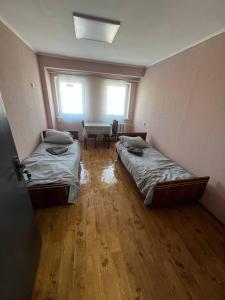 a room with two beds and a table in it at Оазис in Lutsk