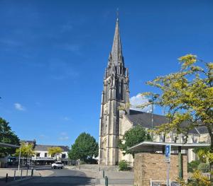 an old church with a steeple on top of it at Beautiful cocooning appartement in La Chapelle-sur-Erdre