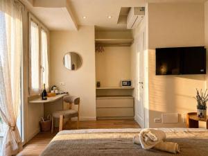 a bedroom with a bed and a desk and a television at Riva Viola in Alassio