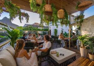 a group of people sitting at a restaurant at Leblon Beach Hostel in Rio de Janeiro