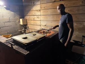 a man is cooking food on a grill at Le manga in Chiconi +11 photos