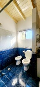two toilets in a bathroom with blue tiles at Los robles suite in San Pedro +11 photos