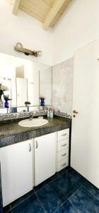 a bathroom with a sink and a large mirror at Los robles suite in San Pedro