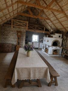 a room with a table with a vase of flowers on it at Kregžlės kaimas in Skirlėnai