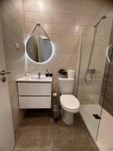 a bathroom with a toilet and a sink and a shower at Casa Maria Olímpia in Nazaré +29 photos
