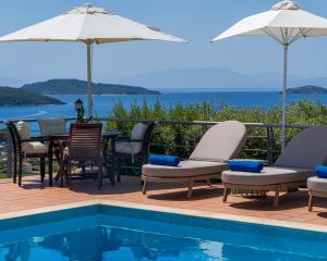 a pool with chairs and a table and an umbrella at Vigles Sea View, Philian Hotels and Resorts in Skiathos