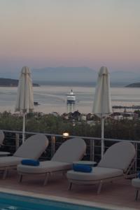 a balcony with chairs and a cruise ship in the water at Vigles Sea View, Philian Hotels and Resorts in Skiathos