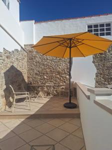 a yellow umbrella sitting on top of a patio at Casa do Arco in Aljubarrota