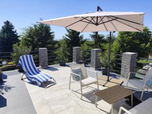 a patio with two chairs and an umbrella at Norbi Vendégház in Balatonszárszó
