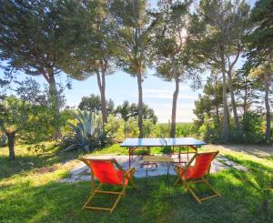 a picnic table and two chairs in the grass at Al Castelluccio in San Vincenzo