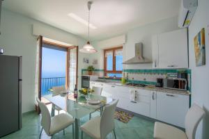 a kitchen and dining room with a glass table and chairs at Calipso Residence in Furore