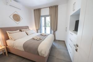 a bedroom with a large bed and a television at Luxury Villa Yvonni in Poros