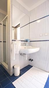 baño con lavabo blanco y suelo azul en Dido, en Roseto degli Abruzzi