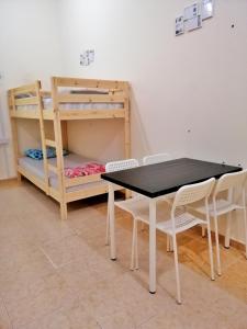 a table and chairs in a room with a bunk bed at Home Line in Doha