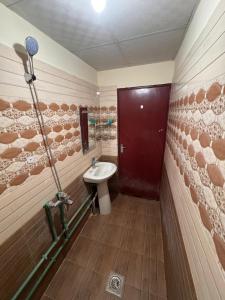 a bathroom with a sink and a red door at Home Line in Doha