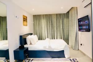 a hotel room with a bed and a large window at House 10 Apartments in Abuja