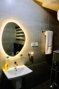 a bathroom with a sink and a mirror at House 10 Apartments in Abuja