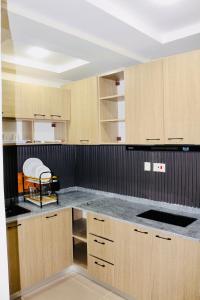 a kitchen with wooden cabinets and a counter top at House 10 Apartments in Abuja