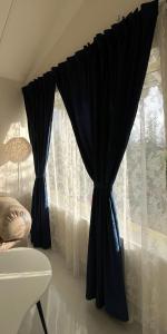 a black curtain on a window in a room at THHPSOCIETY - Taha Cottages in Bhīm Tāl