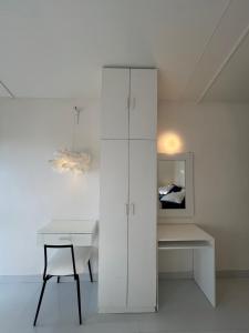 a white room with a desk and a white cabinet at THHPSOCIETY - Taha Cottages in Bhīm Tāl