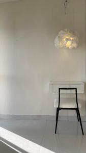 a desk with a chair next to a white wall at THHPSOCIETY - Taha Cottages in Bhīm Tāl
