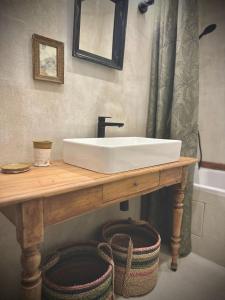 a bathroom with a white sink on a wooden table at Mas Ardéchois de caractère in Labeaume +24 photos