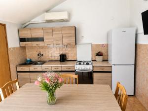a kitchen with a table with a vase of flowers on it at Apartments Izabela Mužić-Fornarić Cres in Cres