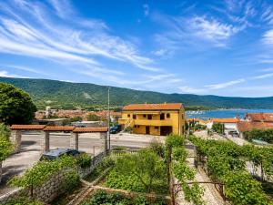 a yellow building with a view of a town and a lake at Apartments Izabela Mužić-Fornarić Cres in Cres