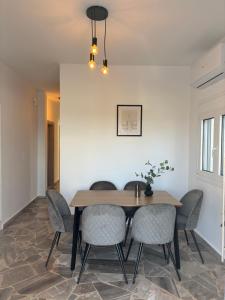 a dining room with a wooden table and chairs at Villa Pano Salamina in Ambelákia