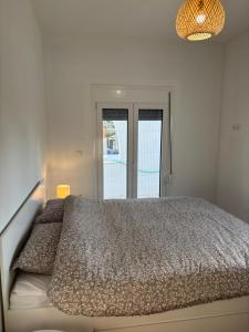 a bedroom with a bed and a large window at Villa Pano Salamina in Ambelákia +23 photos