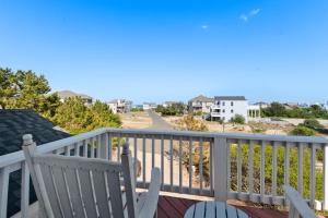 a balcony with chairs and a view of the beach at Dune Deck in Corolla