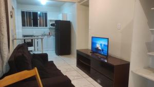 a living room with a couch and a television on a table at Ap cobertura próx Vila Militar, Afonsos e CEFAP in Rio de Janeiro