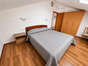 a bedroom with a bed and a wooden floor at Apartments Izabela Mužić-Fornarić Cres in Cres
