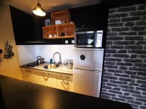a kitchen with a white refrigerator and a microwave at Studio agréable dans résidence in Joué-lès-Tours +7 photos