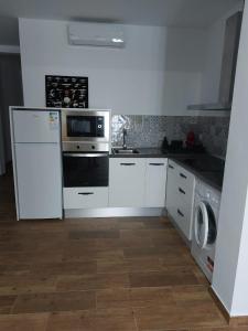 a kitchen with a stove and a washer and dryer at Apartamentos vacacionales malba Bajo A in Punta Umbría
