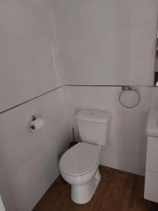 a white bathroom with a toilet and a sink at Apartamentos vacacionales malba Bajo A in Punta Umbría