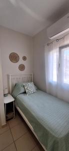 a small bedroom with a bed and a window at Lilli's House in Kassiopi