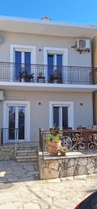 a white building with blue windows and a balcony at Lilli's House in Kassiopi