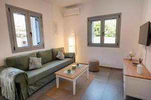 a living room with a green couch and a table at Luxury Villa Yvonni in Poros
