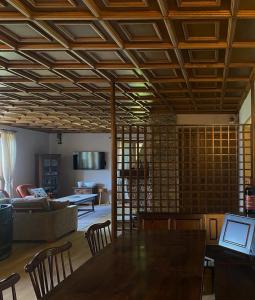 a living room with a wooden ceiling and a table at Chalet il pino in San Bernardo