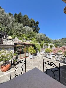 a patio with a table and chairs and trees at Boutique Hotel Vila Aleksander in Berat