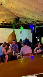 a group of people sitting at a table in a restaurant at A Lounge Hostel in Ella