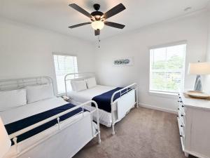 a bedroom with two beds and a ceiling fan at New Home 3br/25br w/ kayak access sleeps 9 in Orange Beach +44 photos
