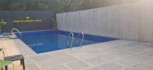 a swimming pool in front of a fence with a sign at Studio Arambol Escape R-8 by Mukund Sadan Arambol in Arambol