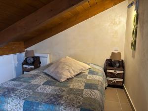 a bedroom with a bed with a quilt on it at La Fenière in Roubion