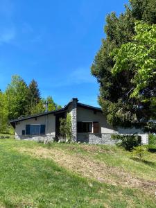 a stone house with a tree in front of it at Chalet il pino in San Bernardo