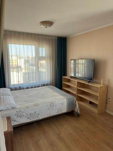 a bedroom with a bed and a flat screen tv at Miga's guest house & tour in Ulaanbaatar