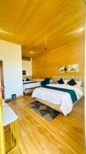 a large bedroom with two beds and a wooden ceiling at Canvas stay by Fairlink in Jāmb