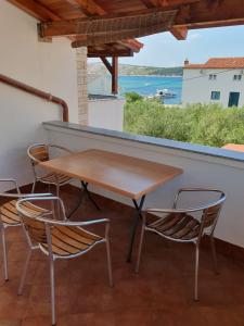 a table and chairs on a balcony with a view of the ocean at Marica Dedić in Barbat na Rabu